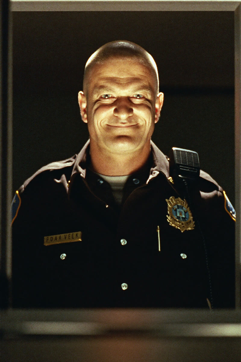 Concept portrait of Minos, a corrections officer lit harshly from below
