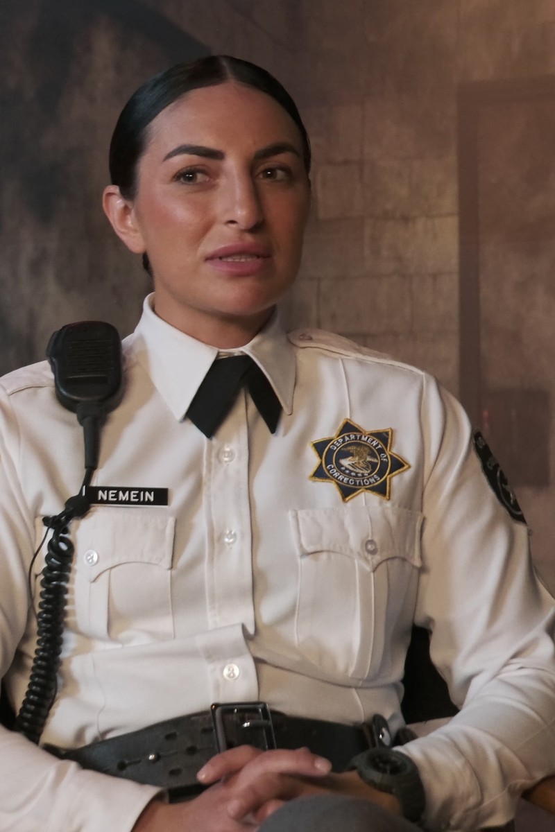 Daria Berenato as Nemein, a corrections officer in uniform against a cell-block wall